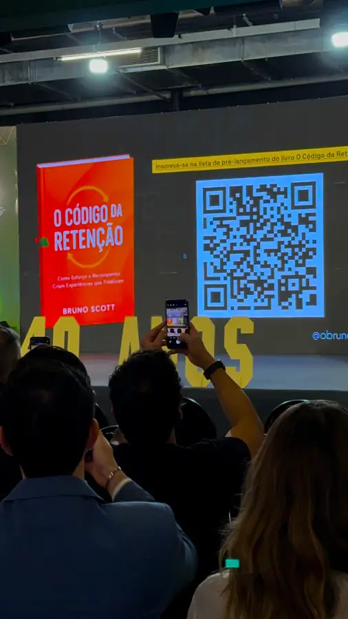 Plateia do ENAF 2026 diante do telão com o livro O Código da Retenção